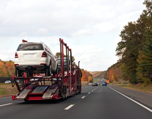 An automotive car carrier truck driving down the highway with a full load of new vehicles.