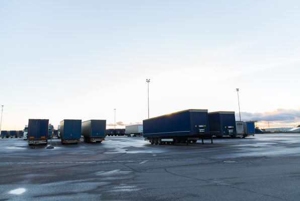 transportation, freight transport and vehicle concept - trucks and trailers on parking